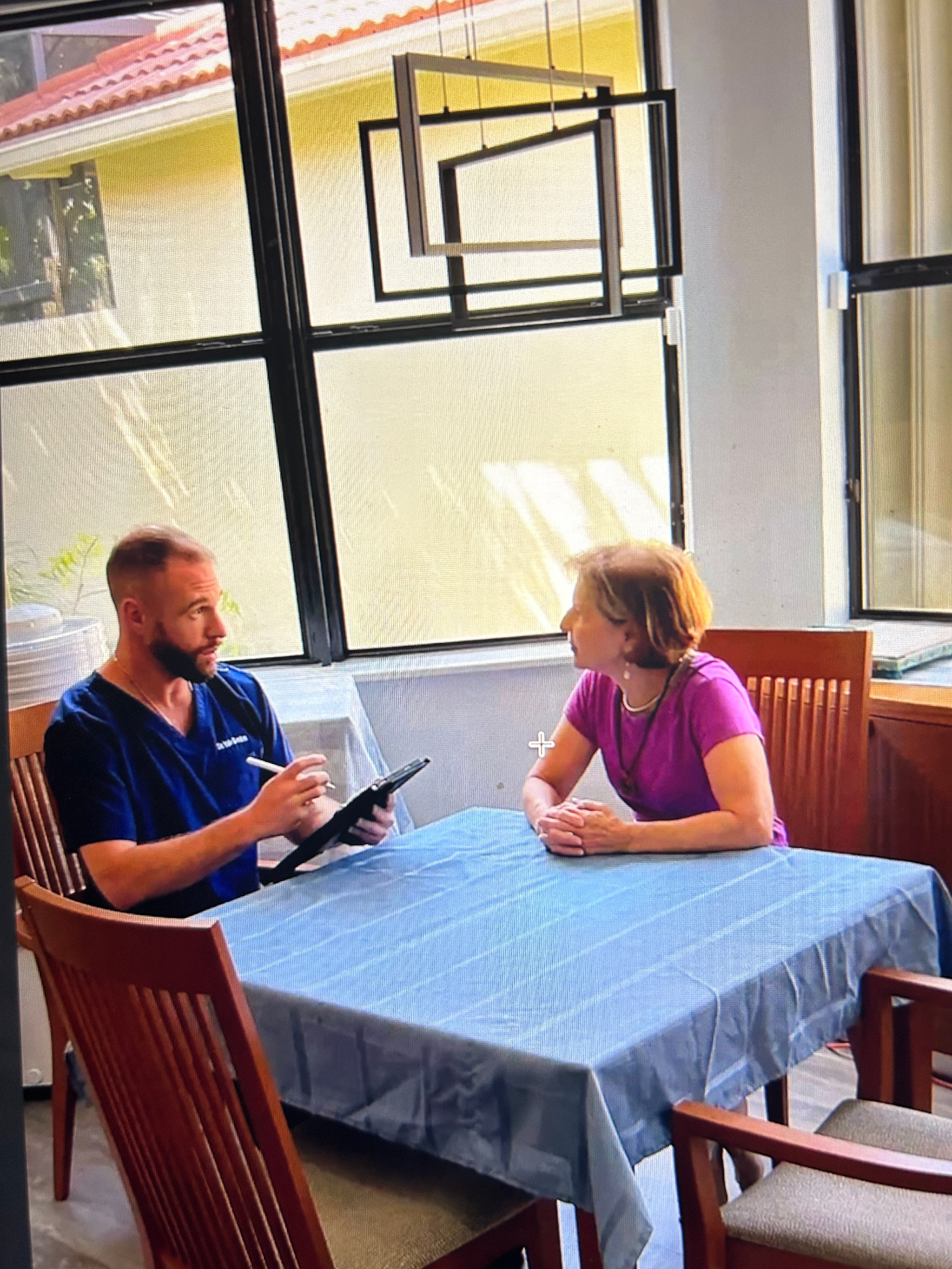 Dr. Gordon consulting with a patient at her dining table during a housecall