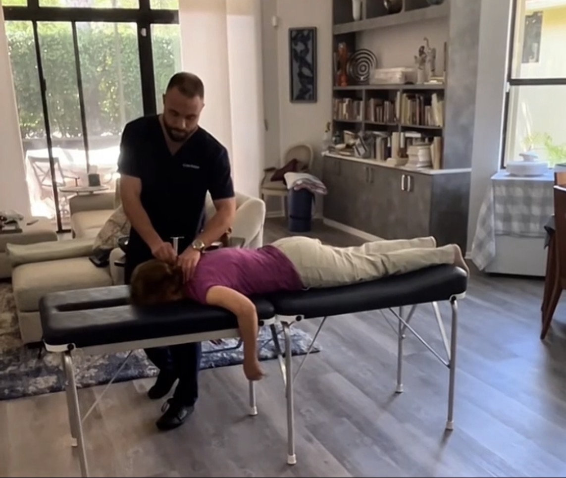 Dr. Gordon performing a gentle Torque Release adjustment in the patient's living room